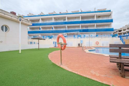 a large building with a swimming pool and a bench at Apartamento Merida in Alcanar
