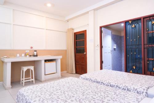 a bedroom with two beds and a table in it at Guesthouse Phuket Airport in Ban Bo Han