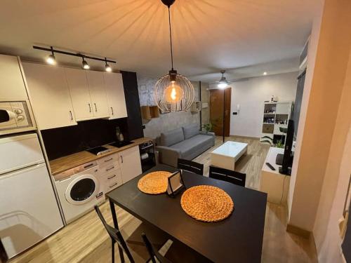 a kitchen with a table and a dining room at Encantador Apartamento en pleno Centro in Jaén