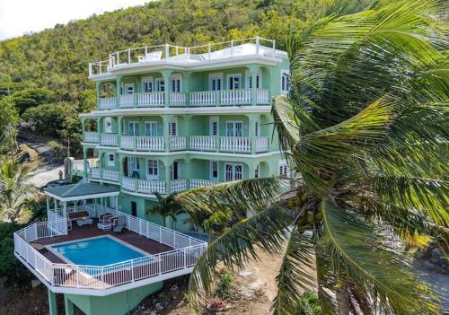 ein großes Haus mit einem Pool und einer Palme in der Unterkunft Wintberg Tropical Villas in Mandal