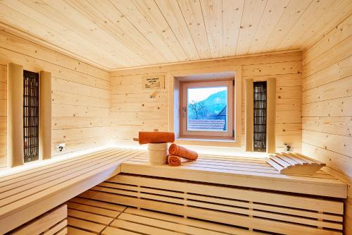 a wooden room with a sauna with a window at Chiemgauferienwohnungen - Stierschneiderhof in Unterwössen