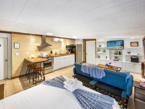 a bedroom with a blue couch and a kitchen at Island Hideout in Charleston