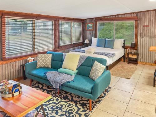 a bedroom with a bed and a couch and chairs at Island Hideout in Charleston