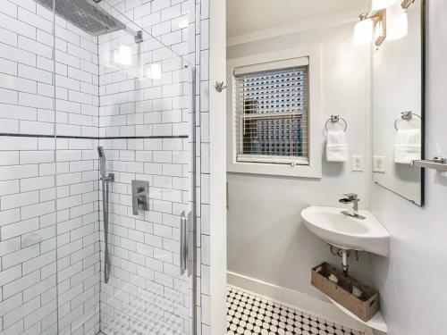 a white bathroom with a sink and a shower at Island Hideout in Charleston