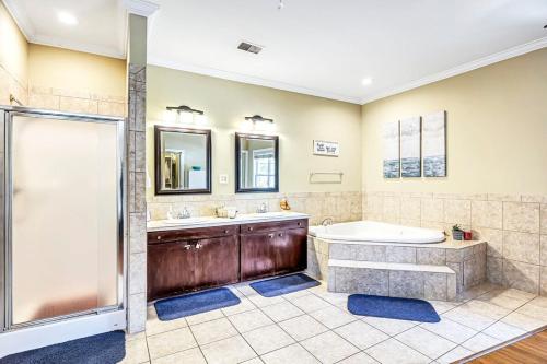 a bathroom with a tub and two sinks and a shower at Island Nest in Charleston