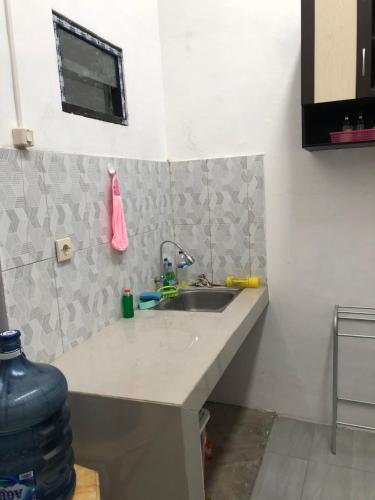 um balcão de cozinha com um lavatório num quarto em Homestay Syariah Orchard Family D30 em Sengkaling