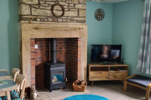 Televízia a/alebo spoločenská miestnosť v ubytovaní Woodcutters Cottage, Northumberland