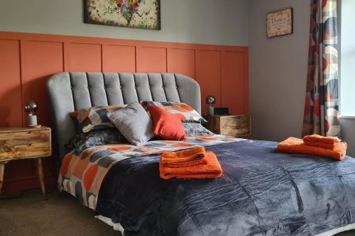 a bedroom with a bed with orange towels on it at Woodcutters Cottage, Northumberland in Haltwhistle
