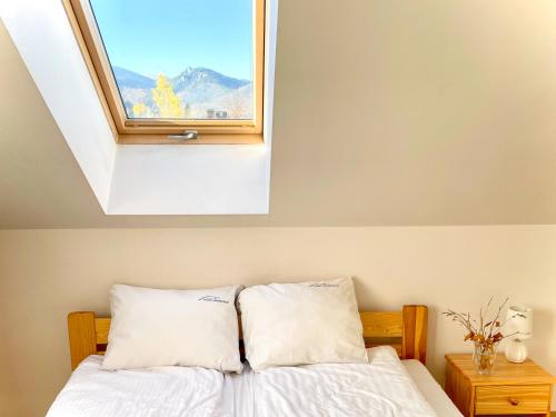 ein Schlafzimmer mit einem Bett und einem Fenster darüber in der Unterkunft VisitZakopane - Lord Apartment in Zakopane