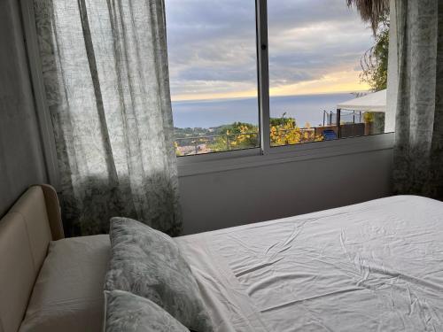 ein Schlafzimmer mit einem Bett und einem großen Fenster in der Unterkunft Villa Oasis Costa Brava in Lloret de Mar