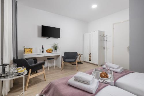 Camera bianca con letto, tavolo e sedie. di Delta Rooms a Fiume (Rijeka)