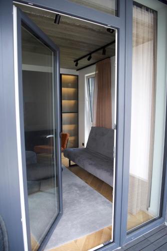 a sliding glass door of a living room with a couch at J. Ralio apartamentai in Vilnius
