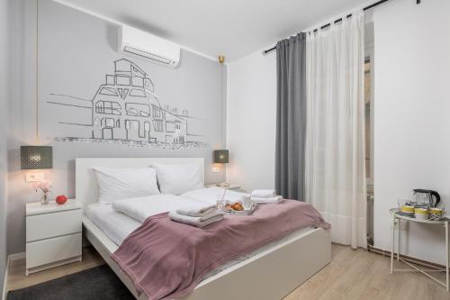una camera da letto bianca con un letto e un tavolo di Delta Rooms a Fiume (Rijeka)