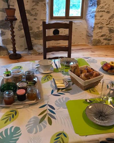 a table with a table cloth with food on it at Chambre d'hôte aux Pivoines in Nistos