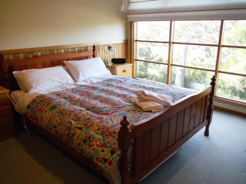 a bedroom with a bed with a quilt on it at 81 on Freycinet in Coles Bay