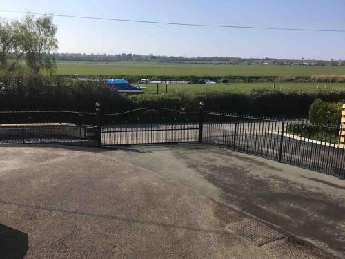 a black wrought iron gate in a driveway at Bens Hollow with hot tub in Bredon