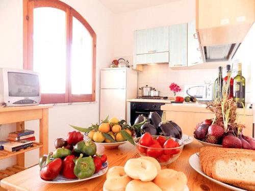 a kitchen with bowls of fruits and vegetables on a table at Le Case di Concetta in Santa Maria