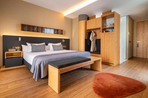 Un dormitorio con una cama grande y un banco. en Ocean Drive Barcelona en Barcelona