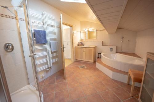 a bathroom with a shower and a tub and a sink at Ferienwohnung Antenbichllehen - Hochthron in Berchtesgaden