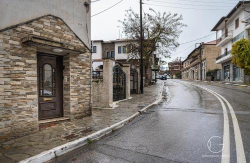 an empty street with a brick building and a door at Guest House Siatista in Siátista
