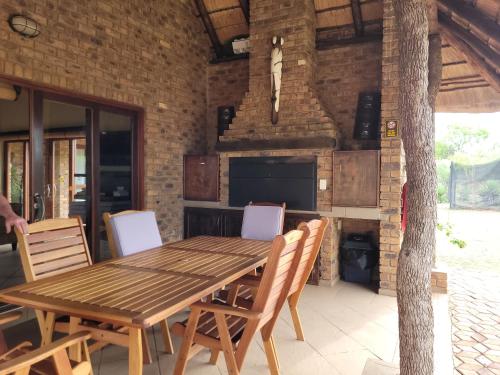 a dining room with a table and chairs and a fireplace at Makhato Bush Lodge 118 in Bela-Bela