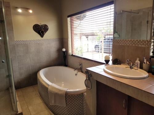 a bathroom with a tub and a sink at Makhato Bush Lodge 118 in Bela-Bela
