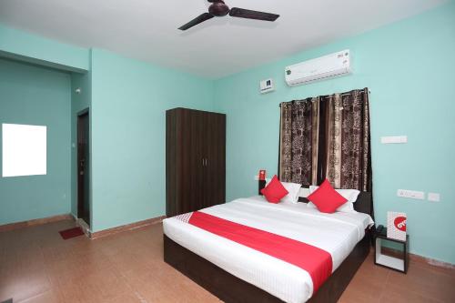 a bedroom with a large bed with red pillows at Flagship The Maple Tree Hotels in Bhubaneshwar