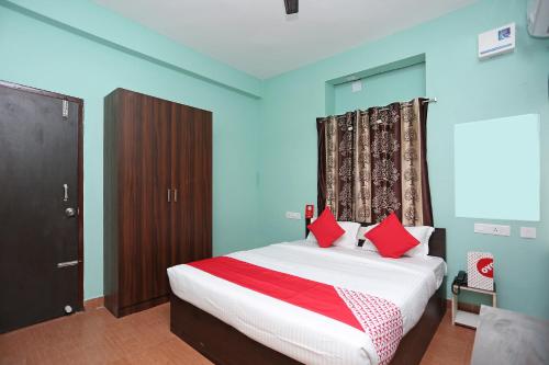 a bedroom with a bed with red pillows at Flagship The Maple Tree Hotels in Bhubaneshwar