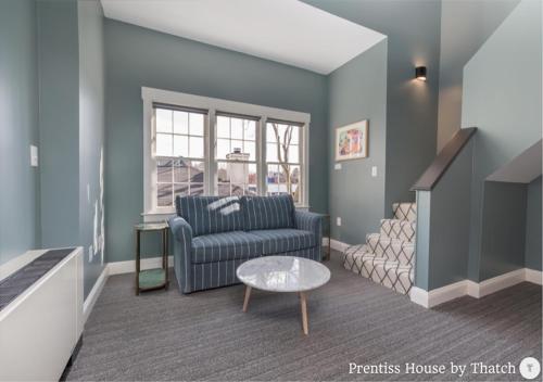 a living room with a couch and a table at Prentiss House by Thatch in Cambridge