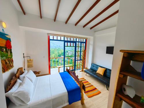 a bedroom with a bed and a large window at Hotel Salento Mirador in Salento