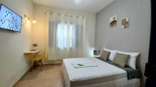 a hotel room with a bed and a window at Quarto em Hospedaria no Centro Histórico in Ouro Preto