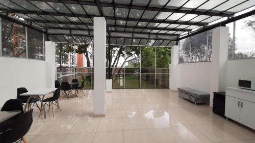 sala de estar amplia con mesa y sillas en Apartasuites AAA Modelia Bogotá, en Bogotá