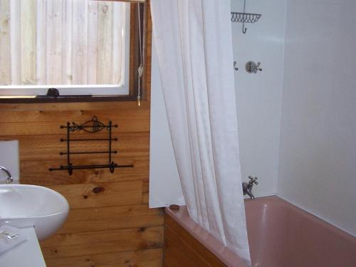 a bathroom with a pink tub and a sink at 81 on Freycinet in Coles Bay