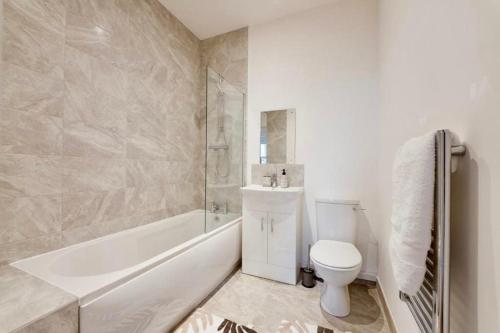 a bathroom with a tub and a toilet and a sink at Flat at Elgin Av Maida Vale W9 in London