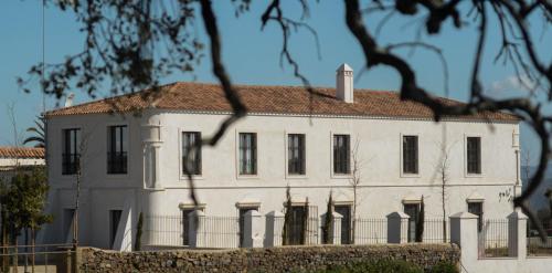 a white house with a fence in front of it at La Dehesa de Don Pedro in Monesterio