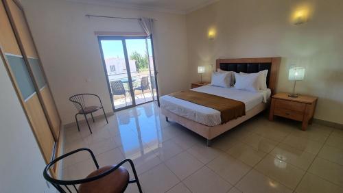 a bedroom with a bed and a table and chairs at Quinta do Pinheiro Premium by Sunny Deluxe in Olhos de Água