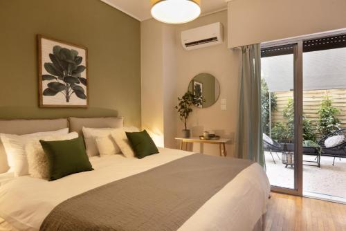 a bedroom with a large white bed with green pillows at Marina Zeas apartment by the sea in Piraeus
