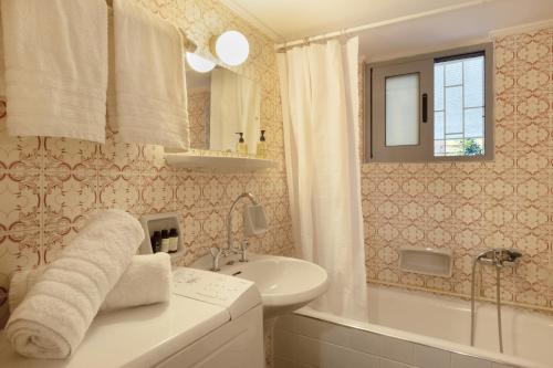 La salle de bains est pourvue d'un lavabo, de toilettes et d'une baignoire. dans l'établissement Marina Zeas apartment by the sea, au Pirée