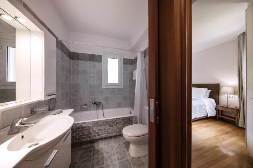uma casa de banho com um lavatório, um WC e uma cama em 2 bedroom flat next to Acropolis em Atenas