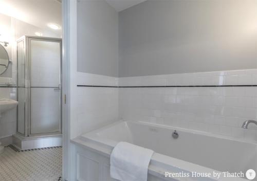 a white bathroom with a tub and a sink at Prentiss House by Thatch in Cambridge