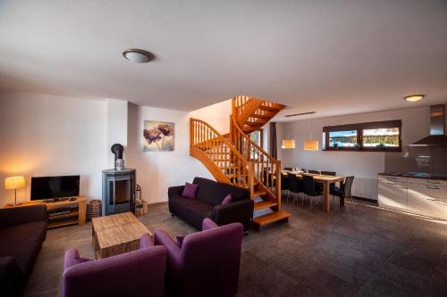 a living room with a spiral staircase and a table at Residence Lipno in Lipno nad Vltavou