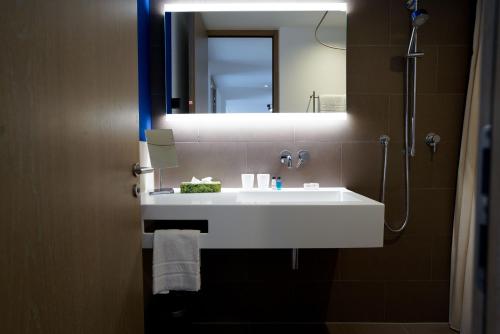 a bathroom with a white sink and a mirror at Max Lodging Serviced Apartments in Munich