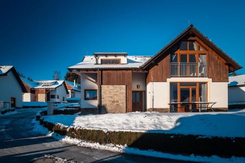 a house with snow on the ground at Residence Lipno in Lipno nad Vltavou