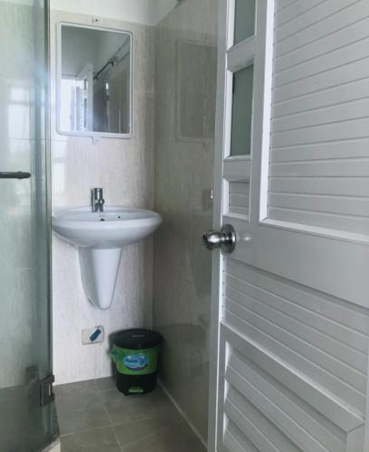 a white bathroom with a sink and a mirror at Nhà nghỉ Phương Dung in Phu Quoc