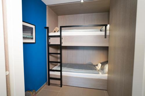 a room with bunk beds with a blue wall at Max Lodging Serviced Apartments in Munich