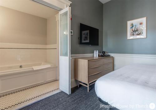 a bedroom with a bed and a bath tub next to a bed sidx sidx sidx at Prentiss House by Thatch in Cambridge