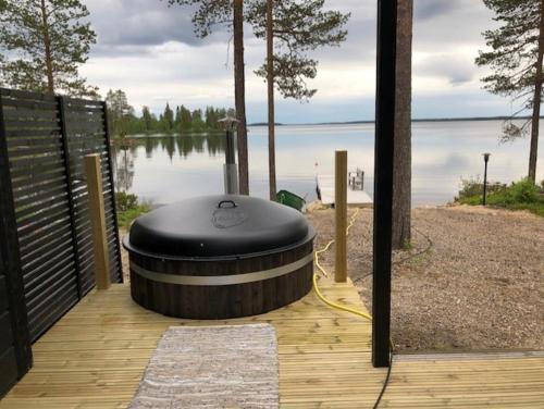 une terrasse en bois avec un grand objet circulaire sur l'eau dans l'établissement Villa Vilmala, à Sääskilahti