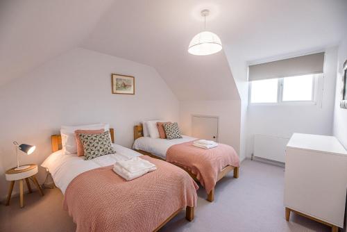 a bedroom with two beds and a window at Chapel House in Woodbridge