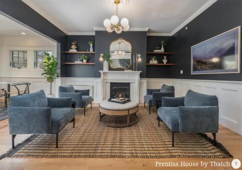 a living room with blue chairs and a fireplace at Prentiss House by Thatch in Cambridge