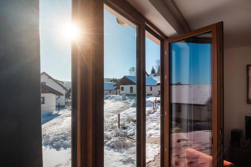 a window with a view of a snow covered yard at Residence Lipno in Lipno nad Vltavou